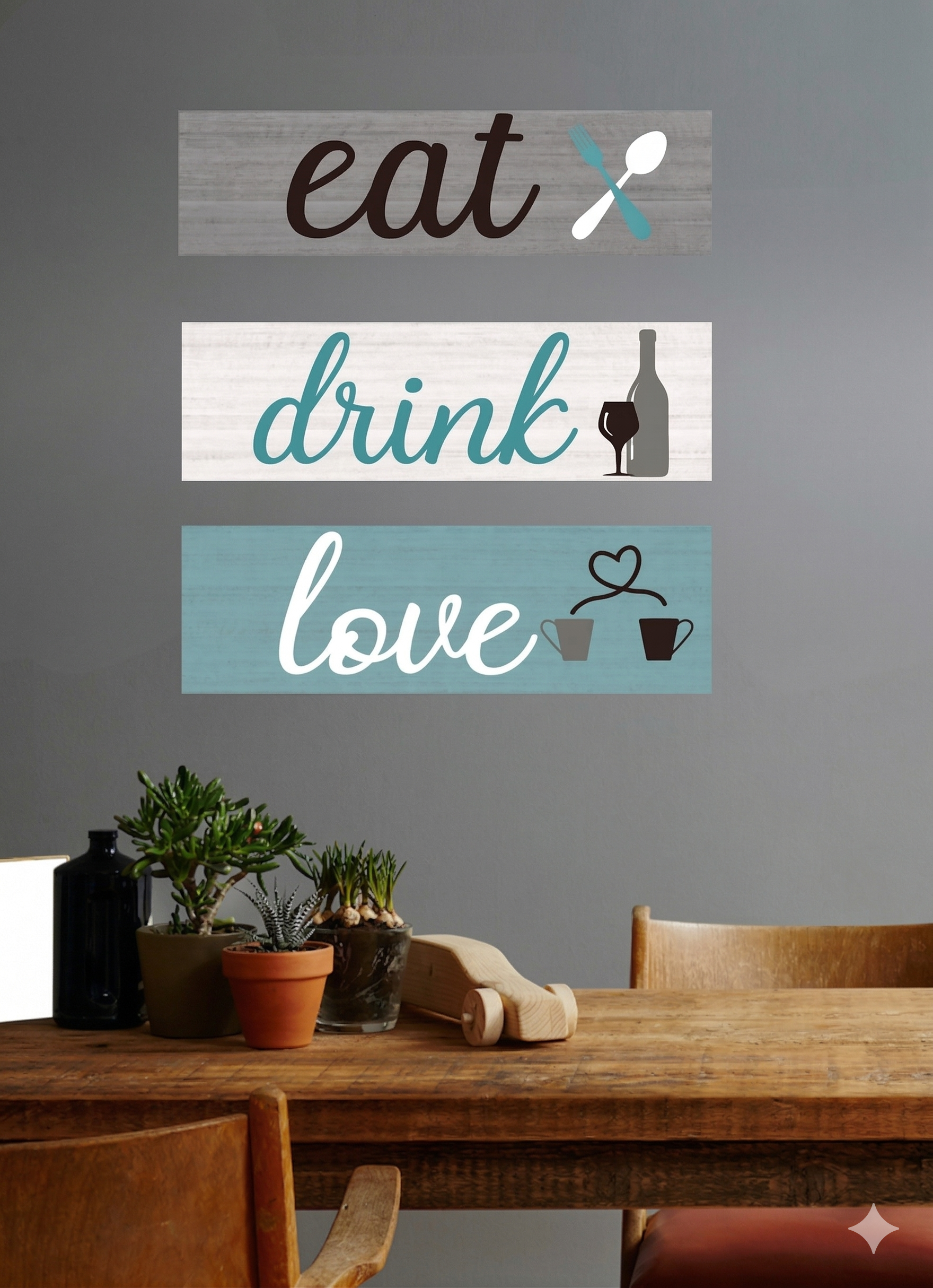 Decorative wall signs with 'eat', 'drink', and 'love' on a gray wall above a wooden table.