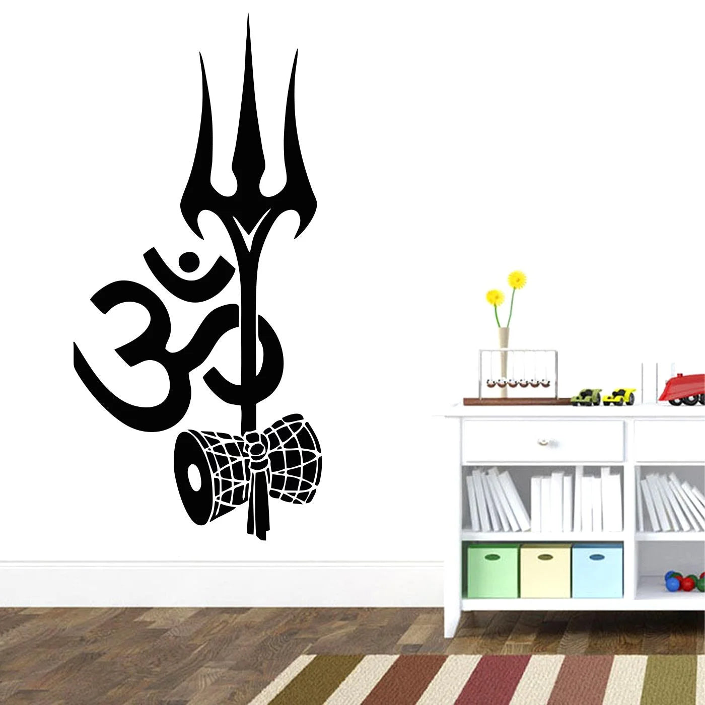 Wall decal of a trident and Om symbol on a white wall with a shelf below.