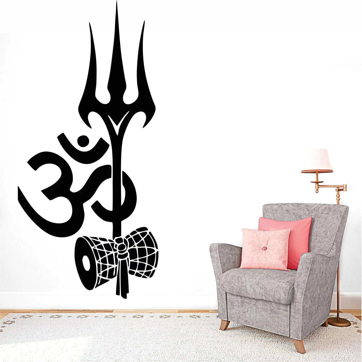 Black trident and Om symbol wall decal on a white wall with a gray armchair and pink pillow.