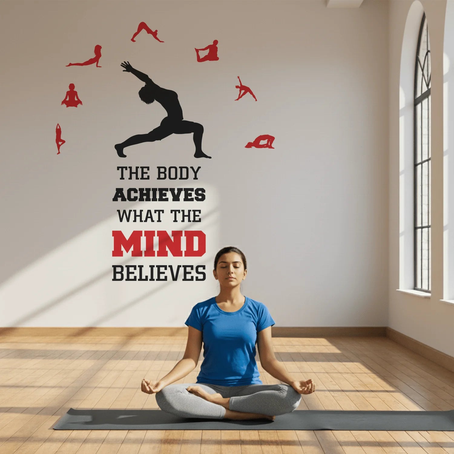 Woman practicing yoga in a room with motivational wall decal