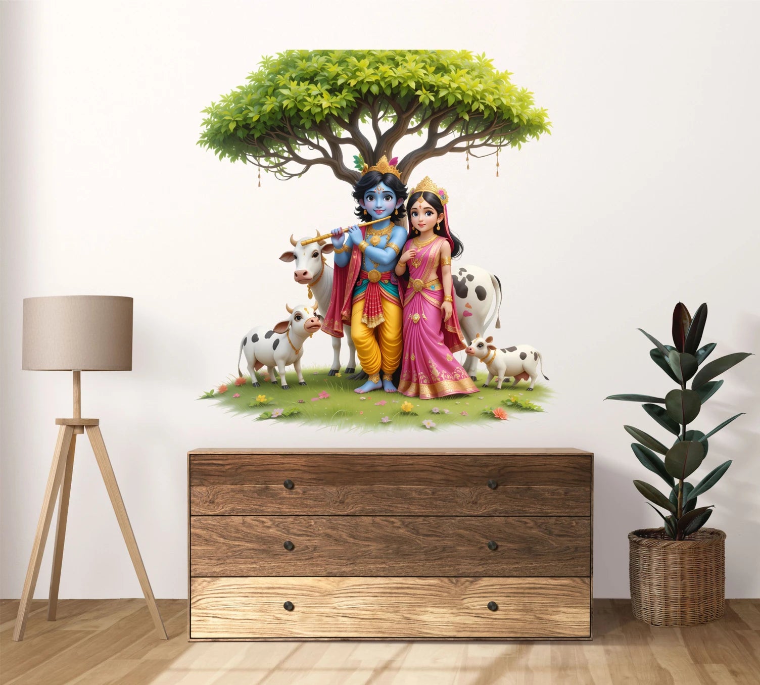 Wall decal of Radha and Krishna with cows and a tree above them on a wall, with a wooden dresser and decor items below.