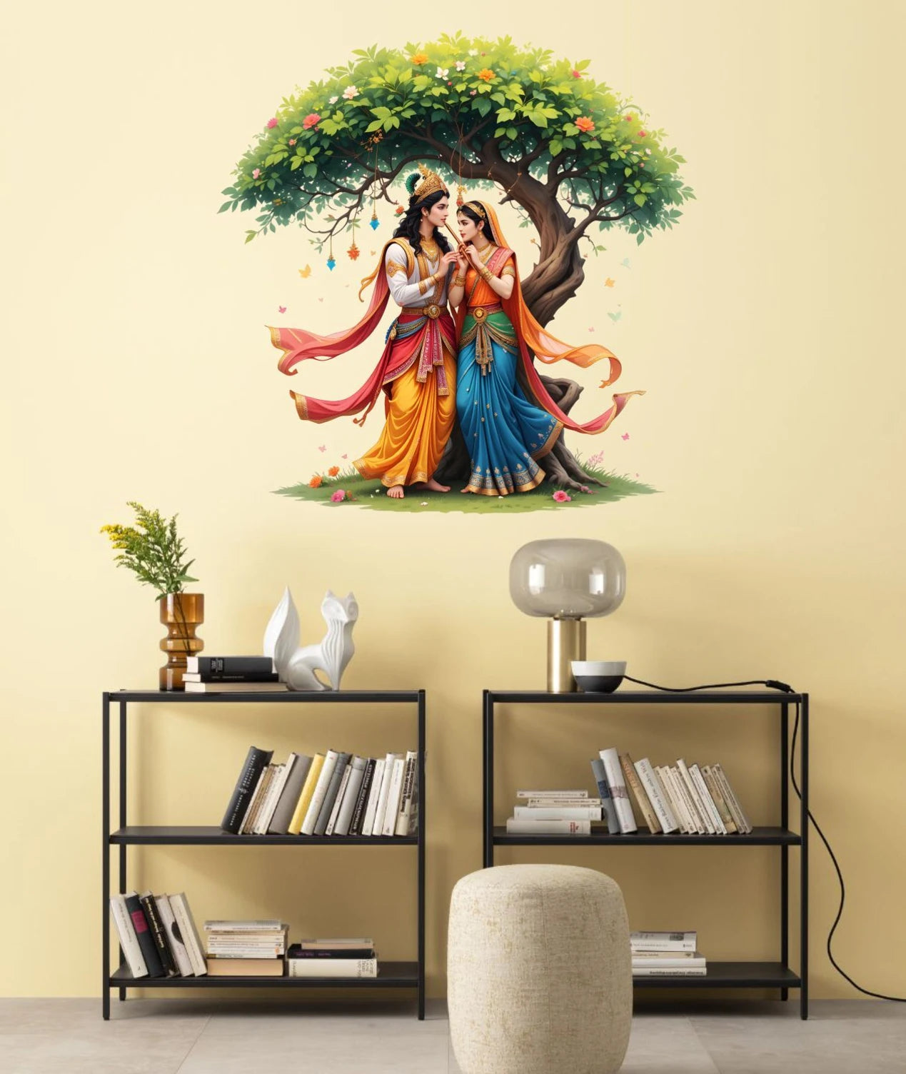 Wall decal of Radha Krishna under a tree in a living room setting with shelves and decor.