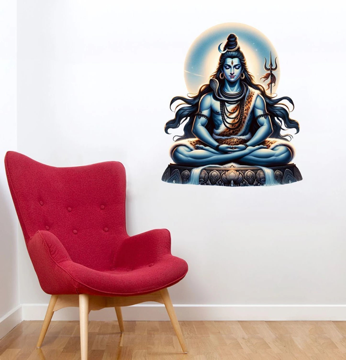Red armchair next to a wall with a large wall decal of a seated Shiva with a trident.