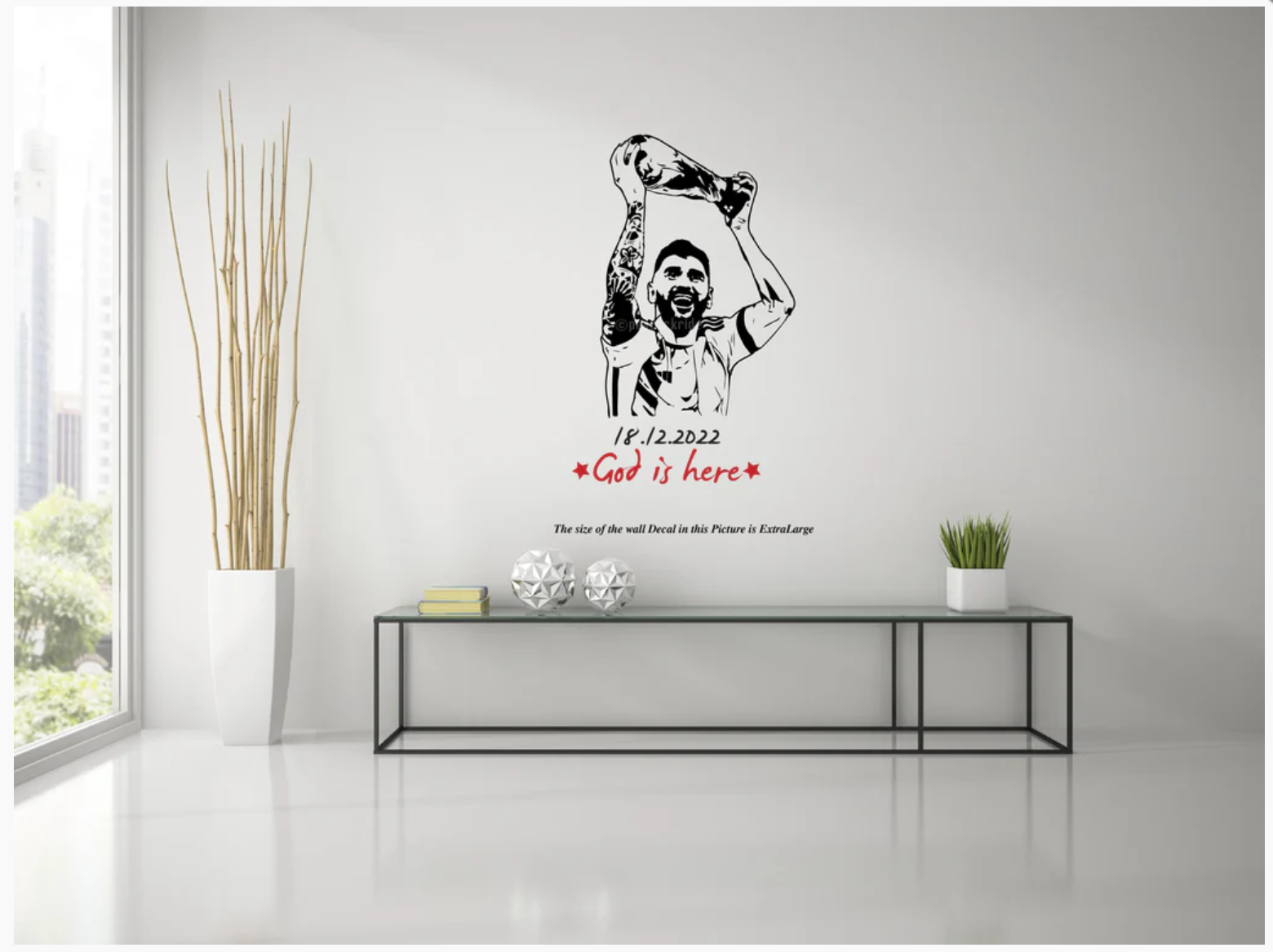 Wall decal of a Messi lifting a cup with text on a white wall in a room with a table and plants.
